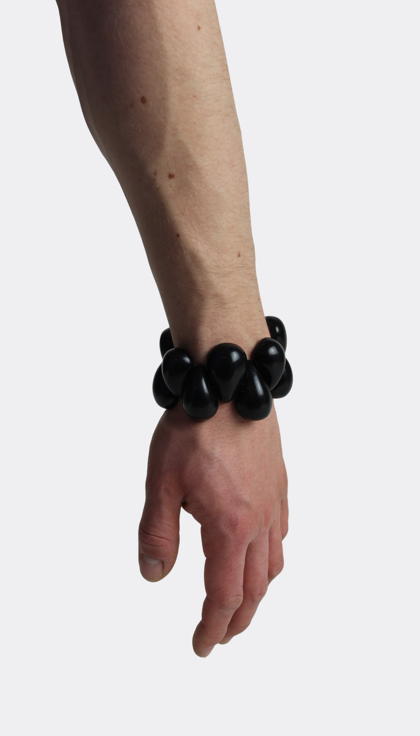 Black tagua nut bracelet on a wrist against a white background