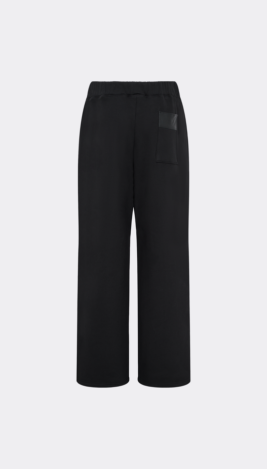 Black wide-leg cropped pants with a drawstring waist and a small dark rectangular patch pocket on the left hip, shown against a light gray background.