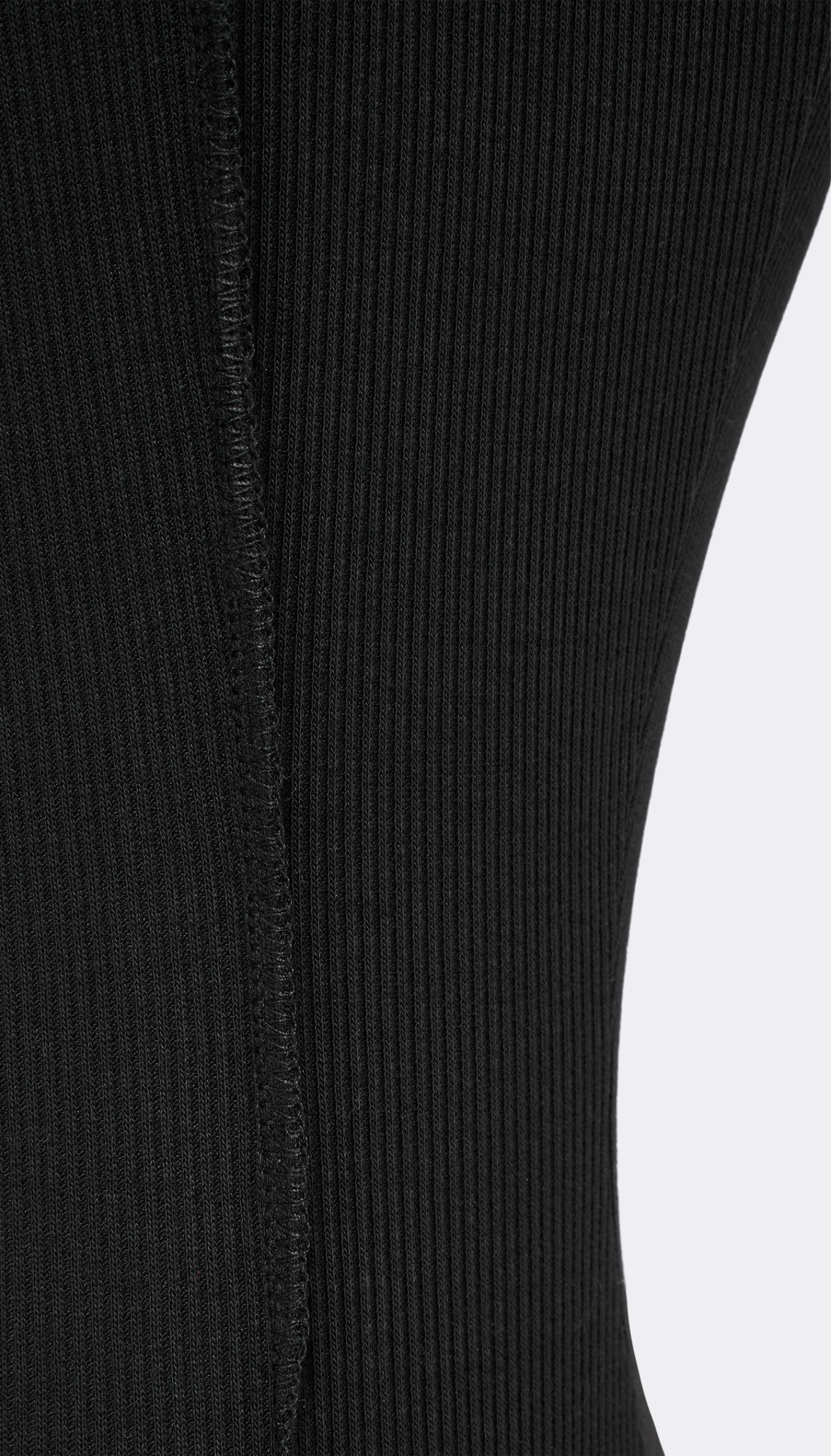 Close-up of a black ribbed knit garment, showing the texture and construction detail against a light gray background.