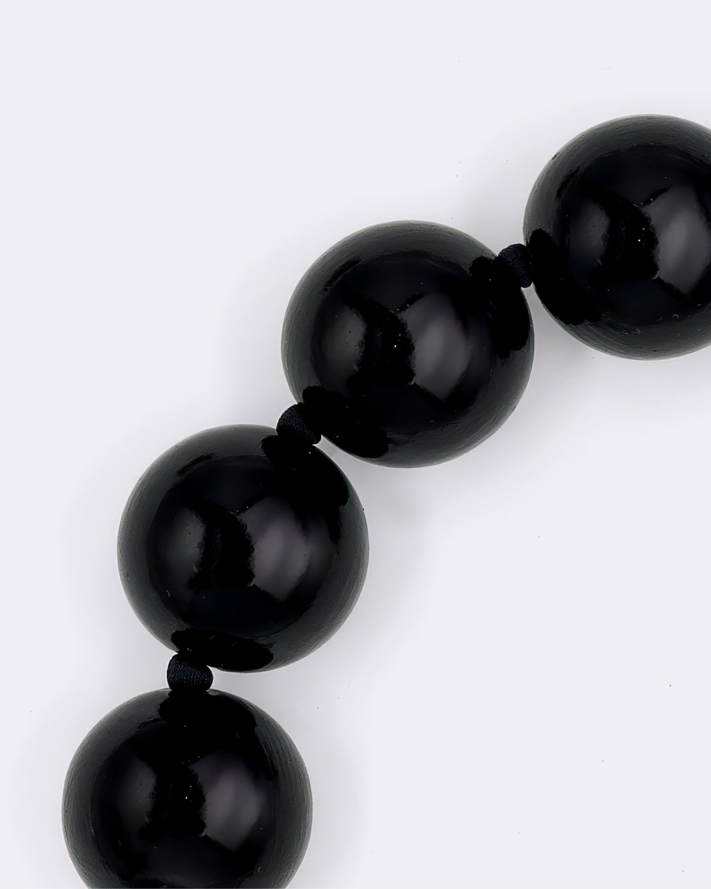 Close-up of a black beaded bracelet on a white background