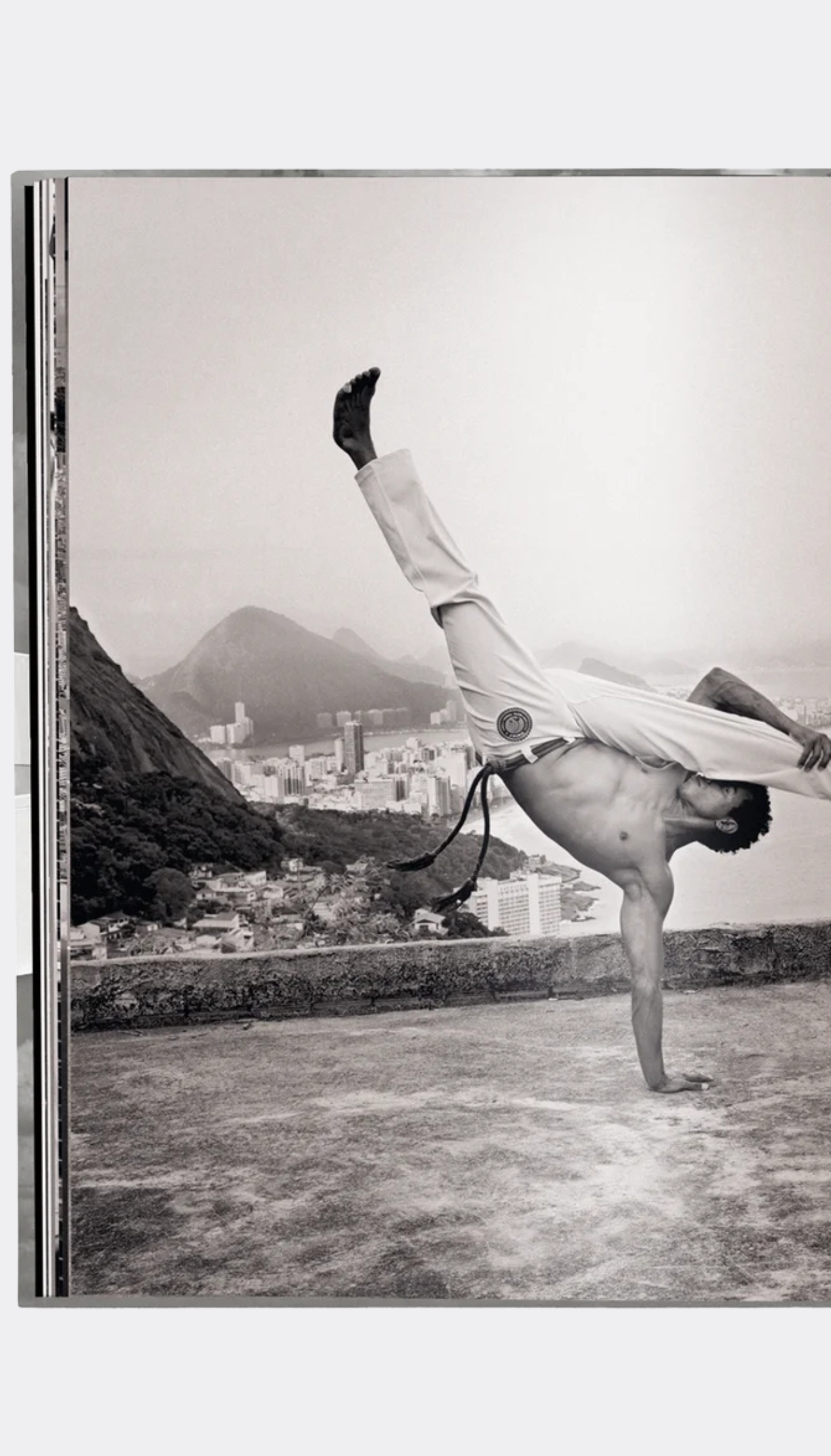 Person performing a handstand with a cityscape and mountain in the background