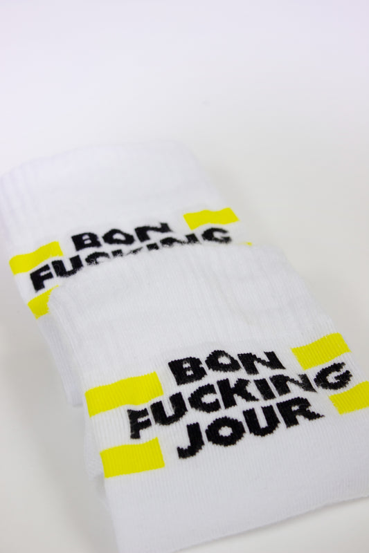 White socks black text 'Bon Fucking Jour' and yellow accents on a white background