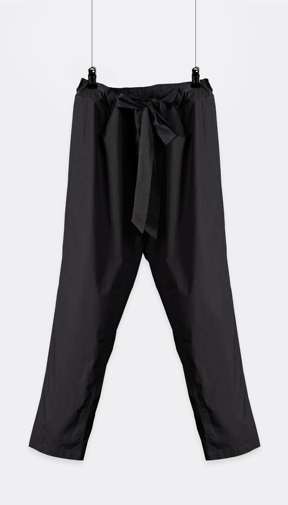 A pair of Outama pants with an integrated belt, hanging against a white background.