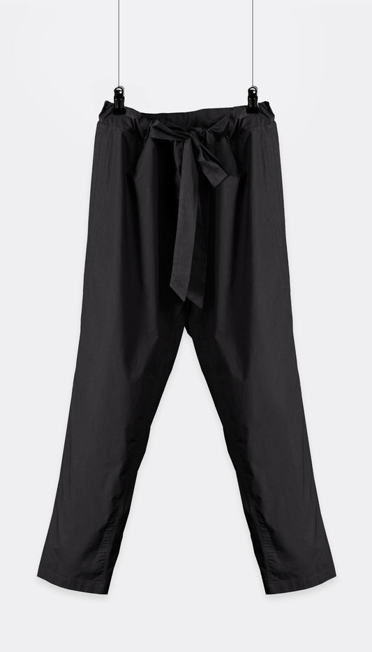 A pair of Outama pants with an integrated belt, hanging against a white background.