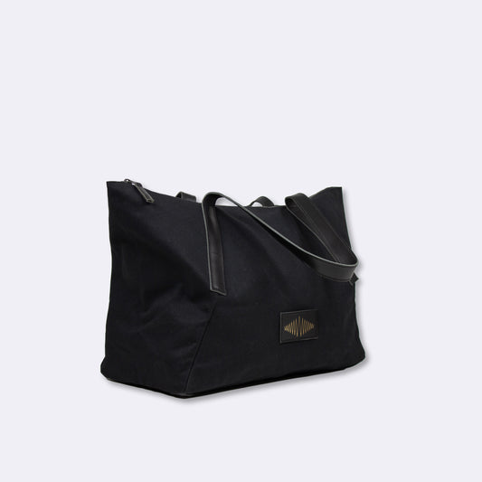 Black everyday weekender bag with a visible gold brand logo on a light gray background