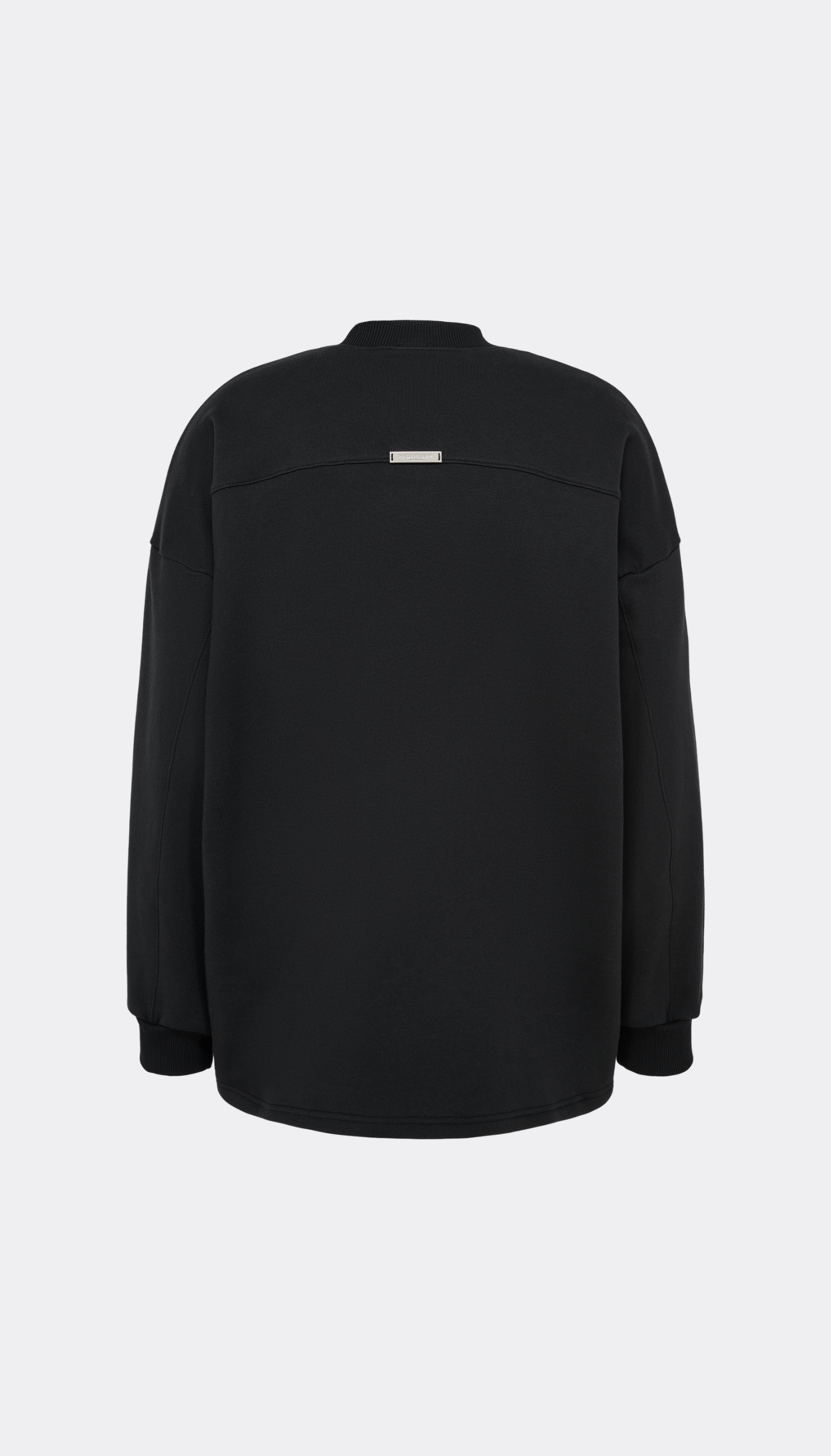 A black long-sleeve pullover jacket from Haderlump shown from the back, featuring a small rectangular silver metallic accent patch near the upper back, set against a light gray background.