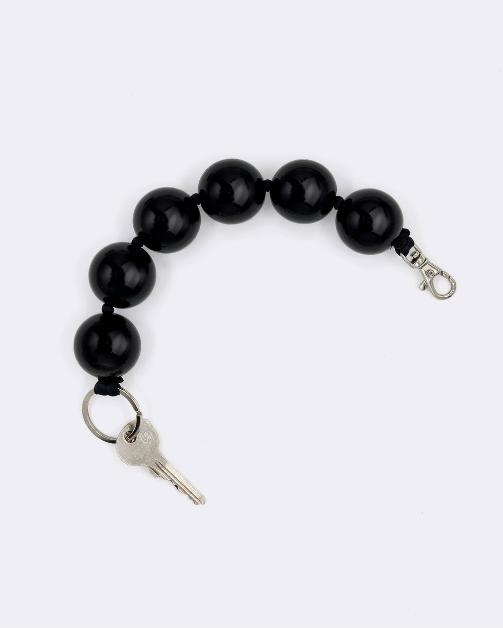 Black beaded keychain by Ina Seifart with a key on a white background
