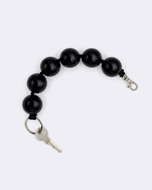 Black beaded keychain by Ina Seifart with a key on a white background