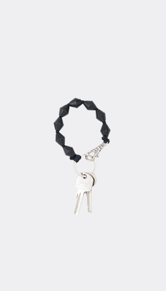 Black beaded keychain with keys on a white background