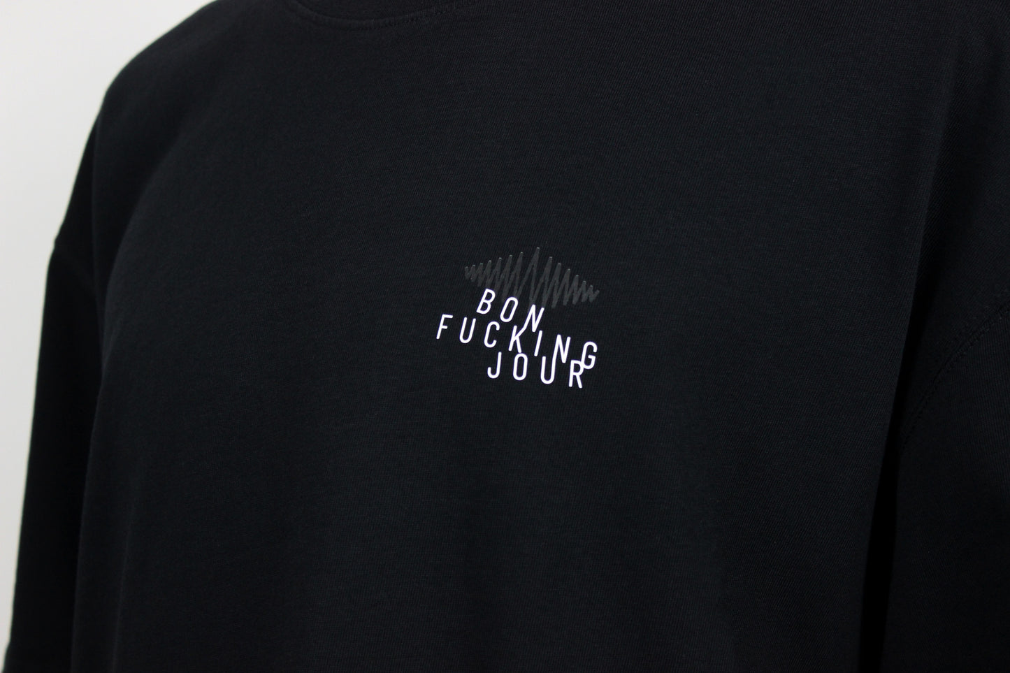 Black t-shirt with white slanted text 'Bon Fucking Jour' on a plain background