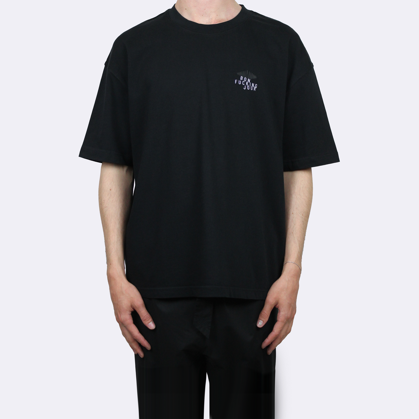 Person wearing a black t-shirt with a small text on a white background