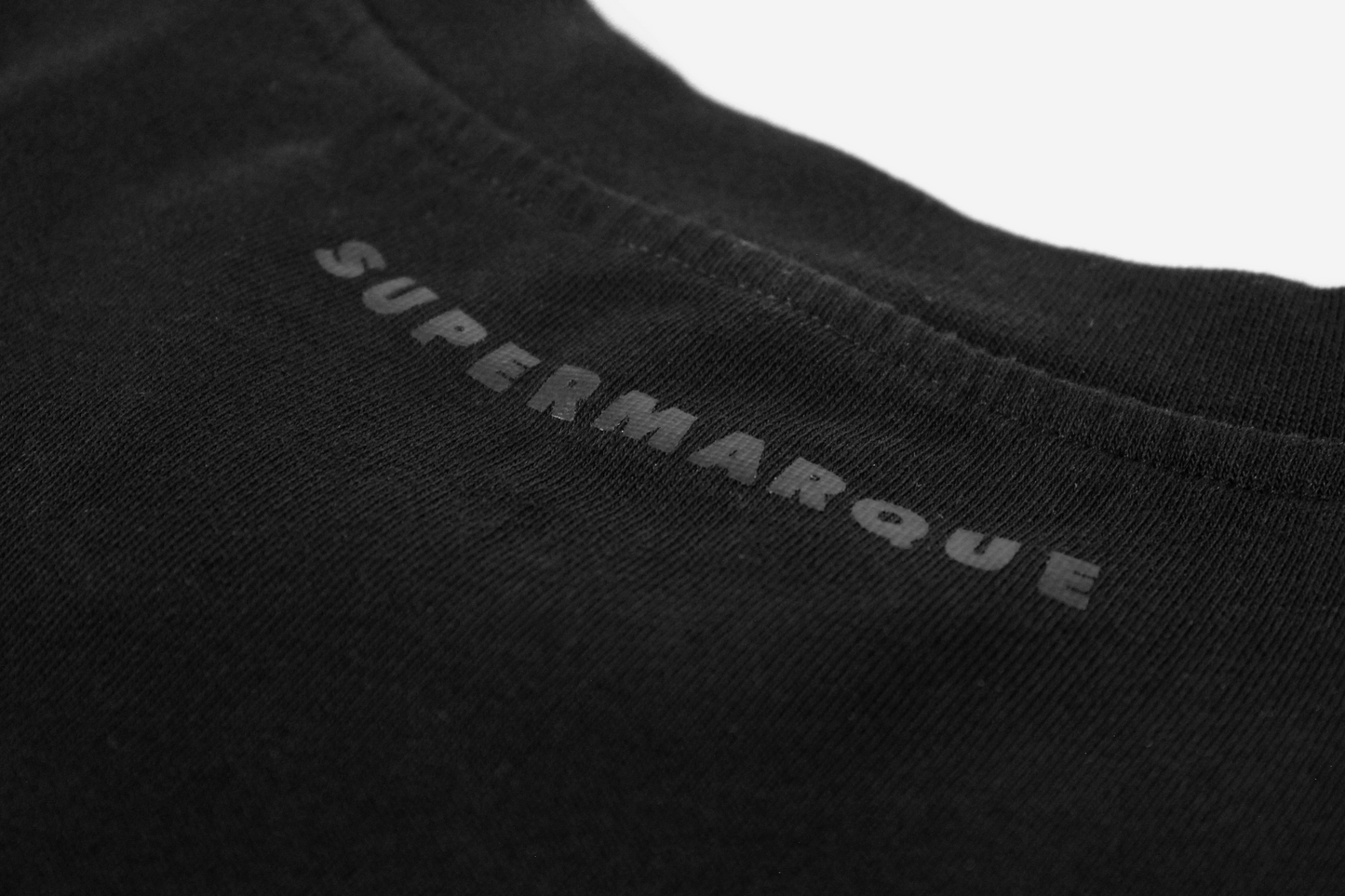Close-up of a black t-shirt with 'Supermarque' branding