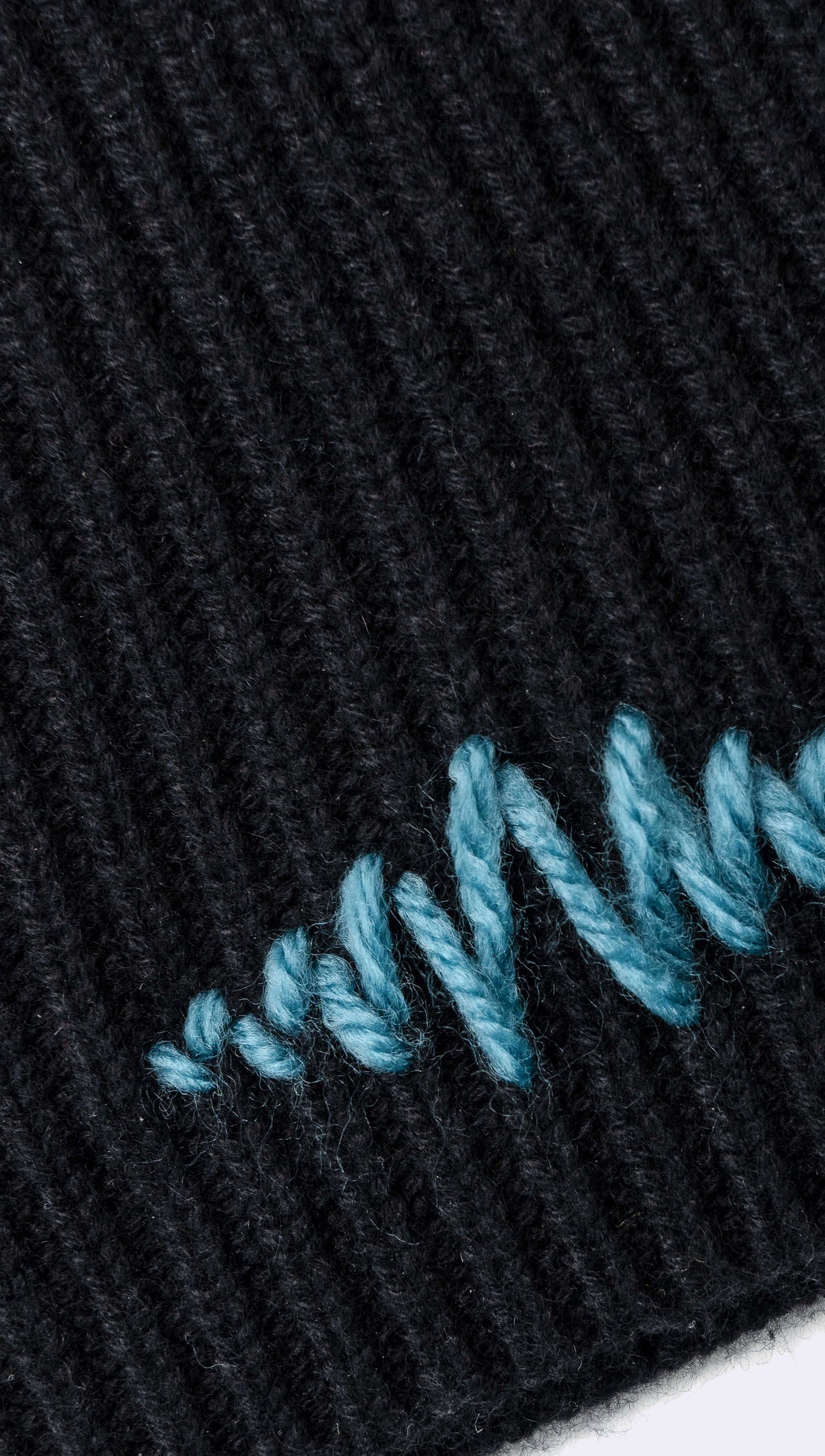 Detail of hand stitched supermarque logo in blue