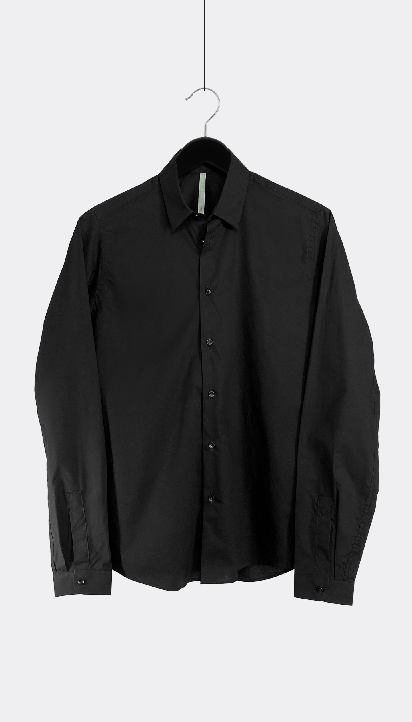 A black cotton poplin shirt with a point collar and buttoned cuffs, hanging against a white background.