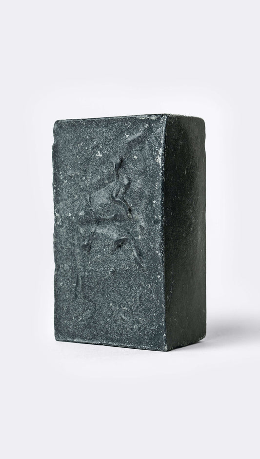 A bar of organic soap with a textured, black surface