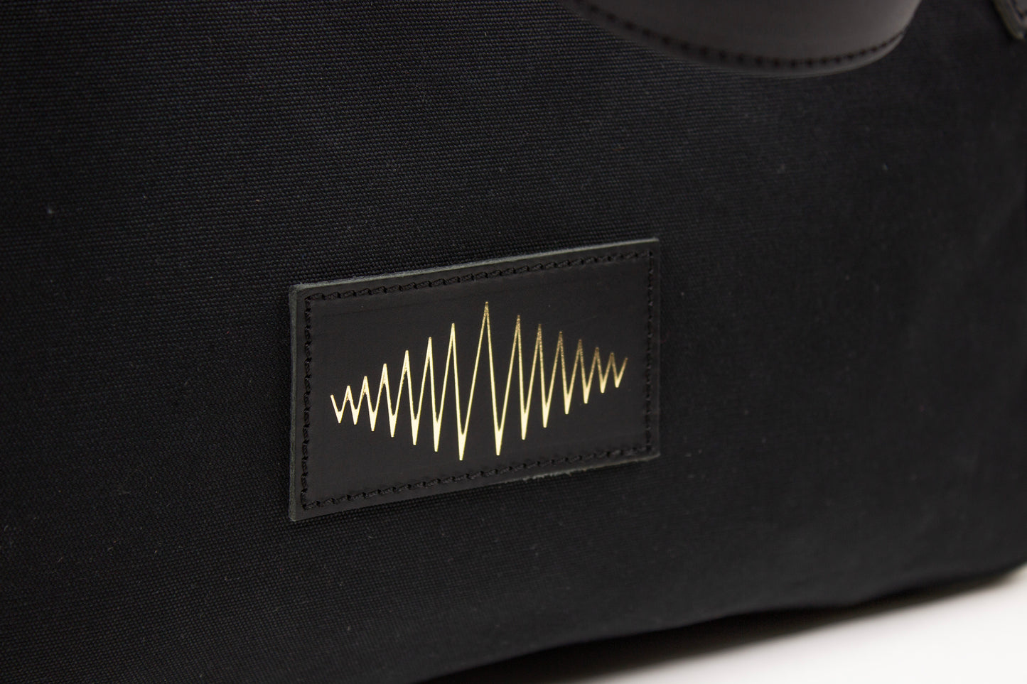 Black bag with a gold SUPERMARQUE logo on a white background